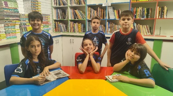 Equipe reunida na biblioteca do colégio