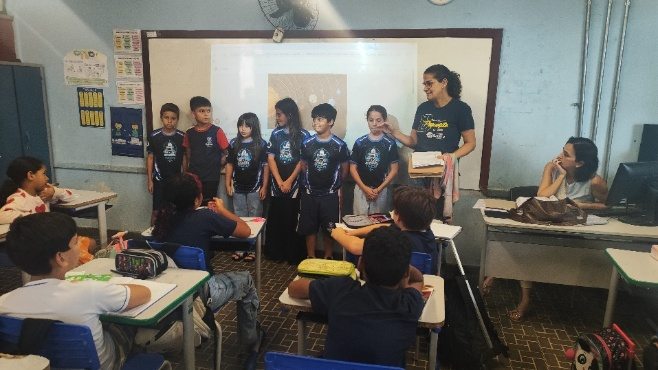 Equipe apresentando para uma turma em sala de aula