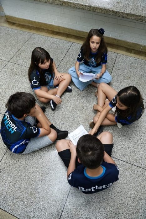 Integrantes sentados em roda estudando juntos